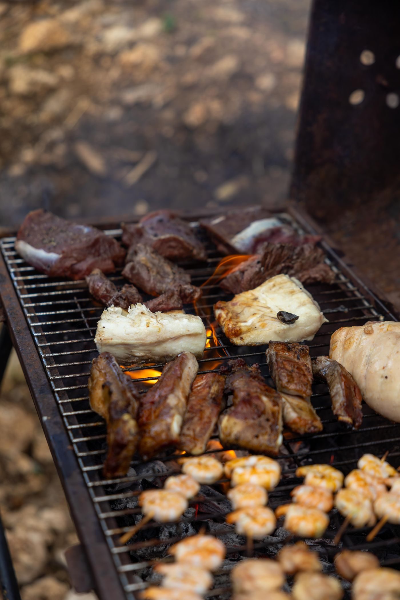 Meat and vegetables grilling over open flames
